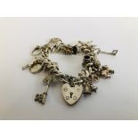 A SILVER CHARM BRACELET WITH PADLOCK CLASP & 15 VARIOUS CHARMS ATTACHED