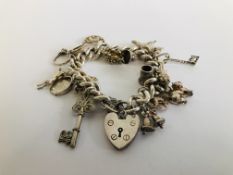 A SILVER CHARM BRACELET WITH PADLOCK CLASP & 15 VARIOUS CHARMS ATTACHED