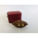 A C19TH JAPANESE CARVED HARDWOOD NETSUKE IN THE FORM OF A BOAT IN LEATHER CASE