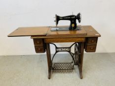 A SINGER SEWING MACHINE IN FITTED WORK TABLE WITH ACCESSORIES