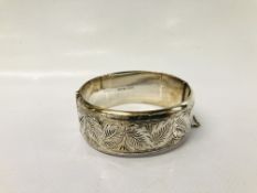 A HINGED SILVER BANGLE WITH CHASED FOLIATE DESIGN MAKER S.P.S & CO.