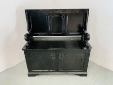 A REPRODUCTION BLACK FINISH MONKS SEAT WITH HINGED TOP AND LION DETAIL - W 96CM. D 42CM. H 72CM.