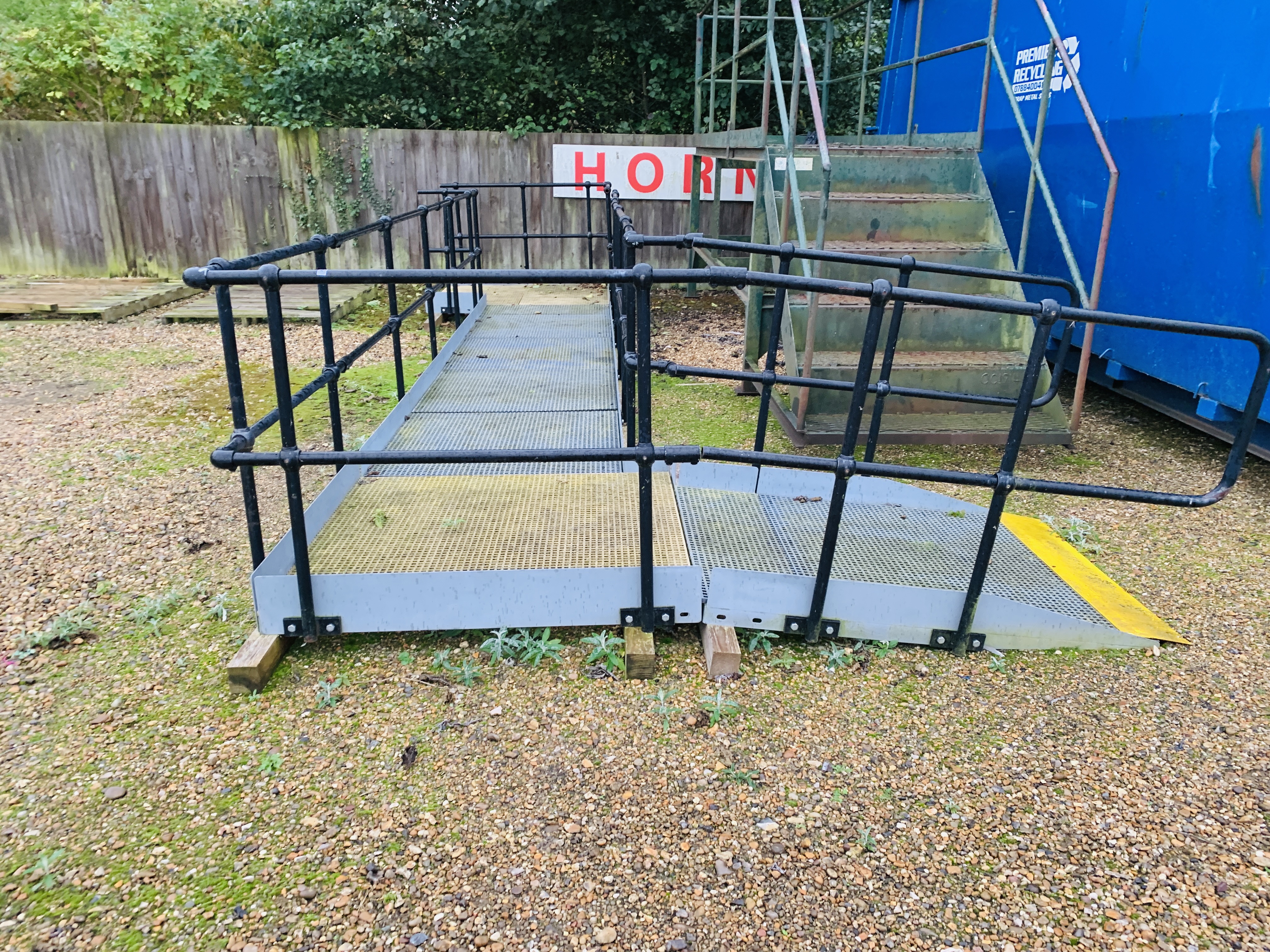 A SECTIONAL GALVANISED STEEL FRAME DISABILITY ACCESS RAMP COMPLETE WITH HANDRAILS AND ADJUSTABLE