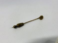 A YELLOW METAL STICK PIN SET WITH SOLITAIRE DIAMOND