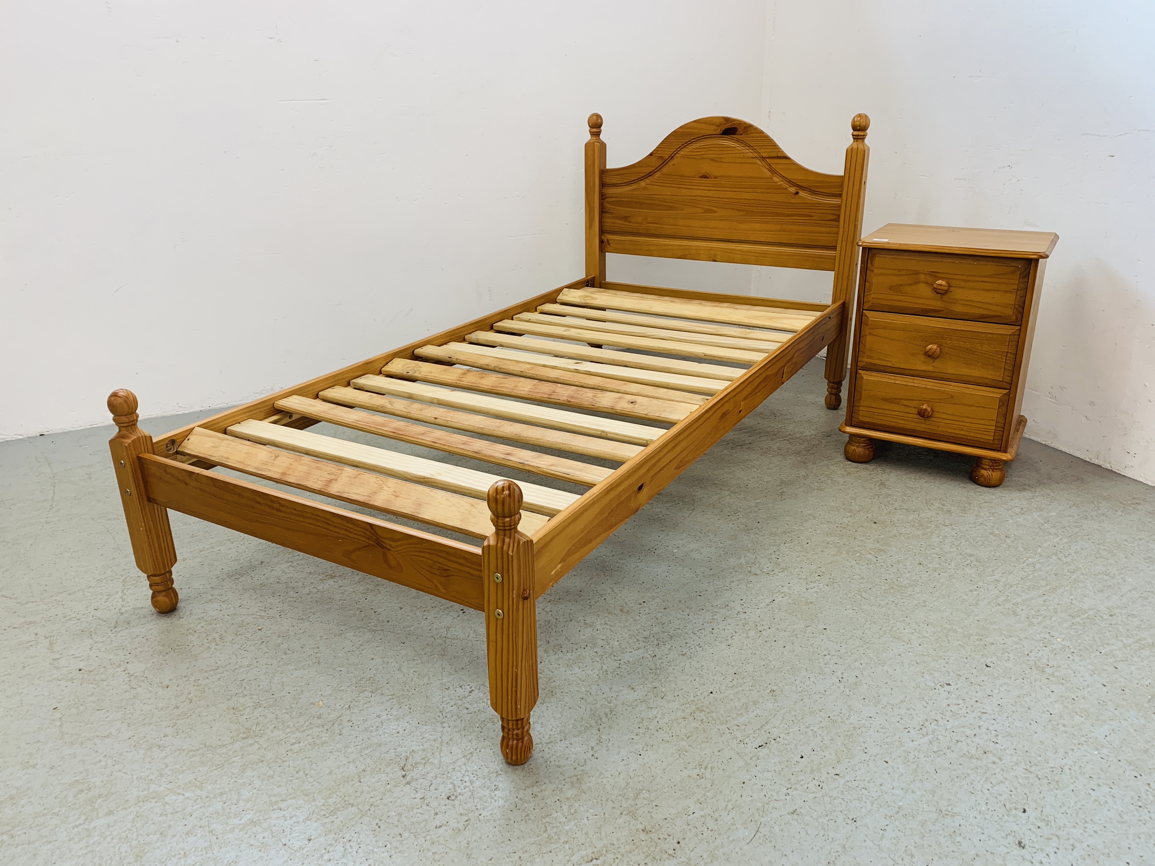 A SINGLE PINE BEDSTEAD AND PINE THREE DRAWER BEDSIDE CHEST