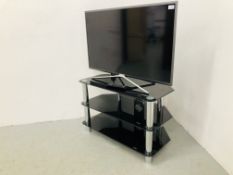 SAMSUNG 40" FLAT SCREEN TV - MODEL UC40K5500AK ON GLASS THREE TIER STAND - REMOTE WITH AUCTIONEER -