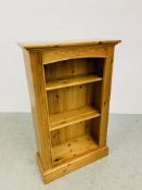 A SOLID HONEY PINE BOOKSHELF WITH TONGUE AND GROOVE BOARDED BACK - W 66CM. D 26CM. H 107CM.