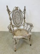 AN ORNATE AND UNUSUAL CANE ELBOW CHAIR, THE FINISH WORN,