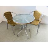 A METAL FRAMED GARDEN BISTRO SET COMPRISING OF A SMALL CIRCULAR GLASS TOP TABLE AND 2 CHAIRS