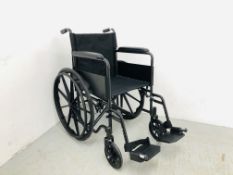 A CARE CO MANUAL WHEELCHAIR COMPLETE WITH FOOT PEDALS IN BLACK ON SOLID RUBBER WHEELS