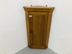 A LIGHT OAK WALL MOUNTED CORNER CABINET