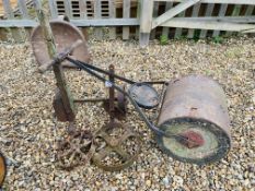 A VINTAGE CAST IRON AND CONCRETE GARDEN ROLLER ALONG WITH 2 SMALL CAST WHEELS AND VINTAGE SACK