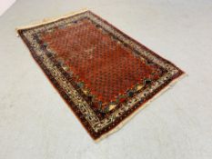 AN EASTERN RED / BLUE PATTERNED RUG - 162 X 103CM.