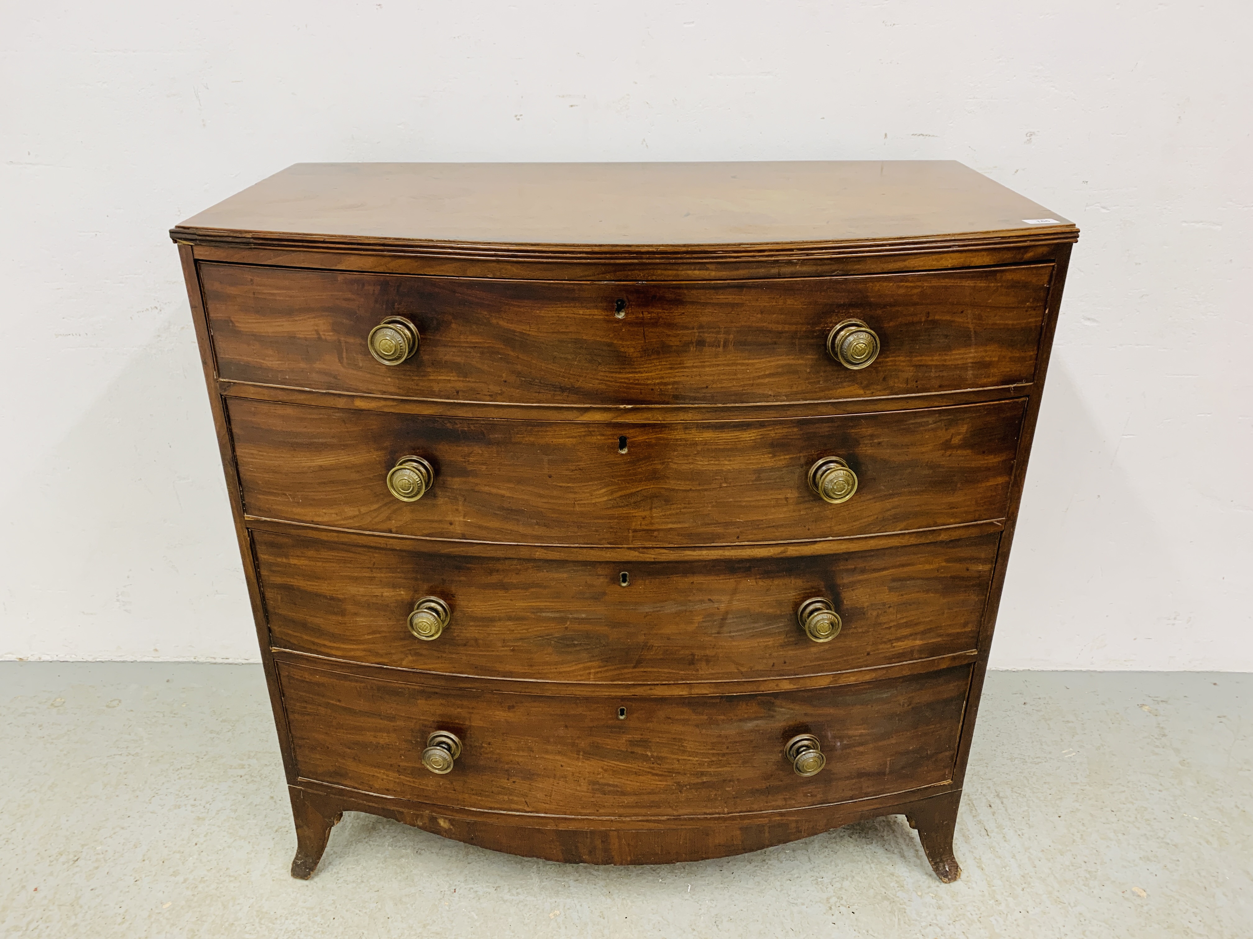 A GEORGE III MAHOGANY BOW FRONT CHEST OF FOUR LONG DRAWERS WITH LATER HANDLES
