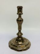 A CONTINENTAL CAST SILVER CANDLESTICK, THE GADROONED COLUMN ON A STEPPED AND SCROLLED BASE - 21.