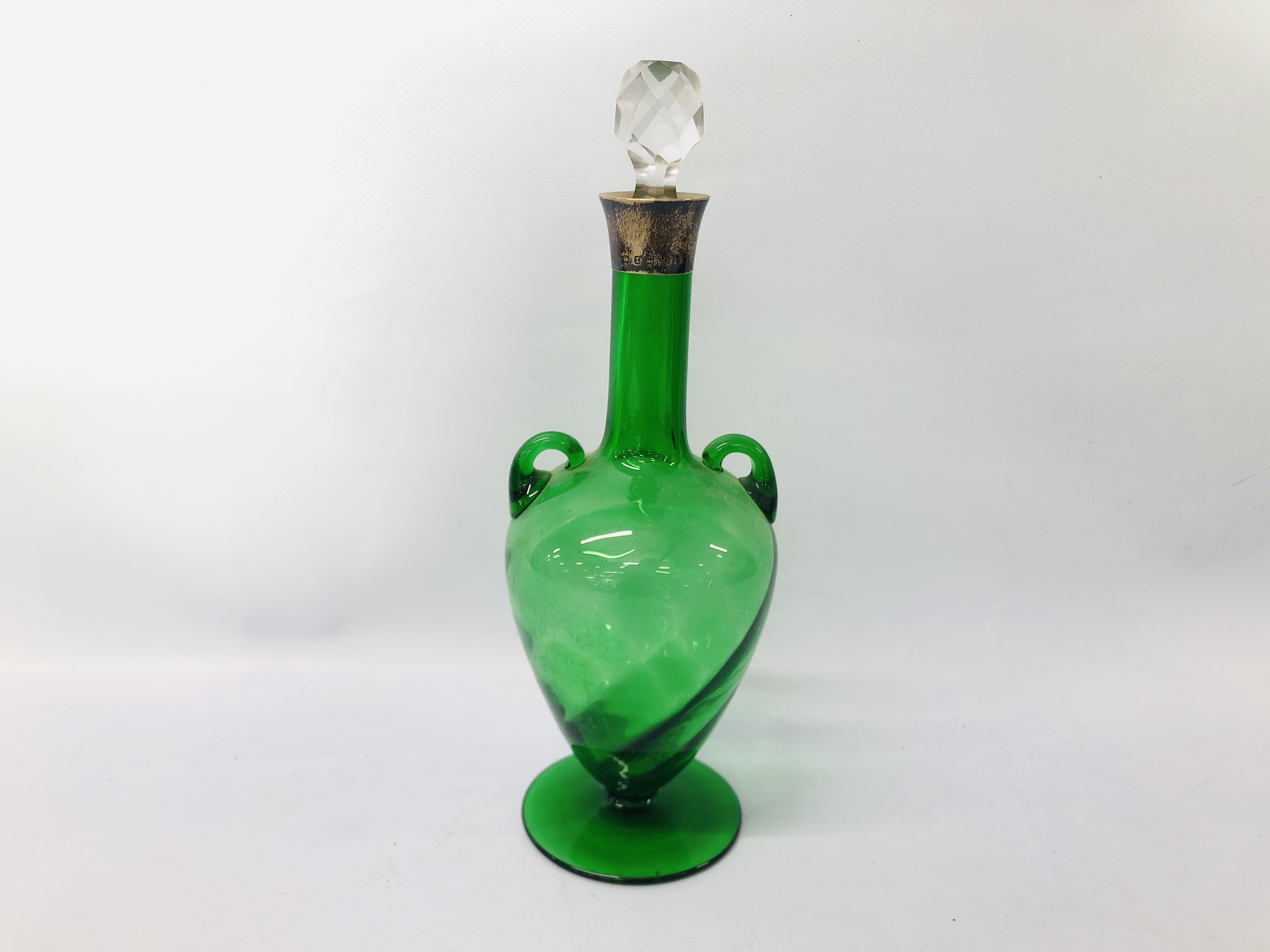 A GREEN GLASS DECANTER WITH TWO HANDLES, SILVER MOUNT,