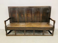 AN EARLY C18TH OAK SETTLE WITH FIVE PANELLED BACK ON BOBBIN TURNED SUPPORTS - W 197CM. D 50CM.