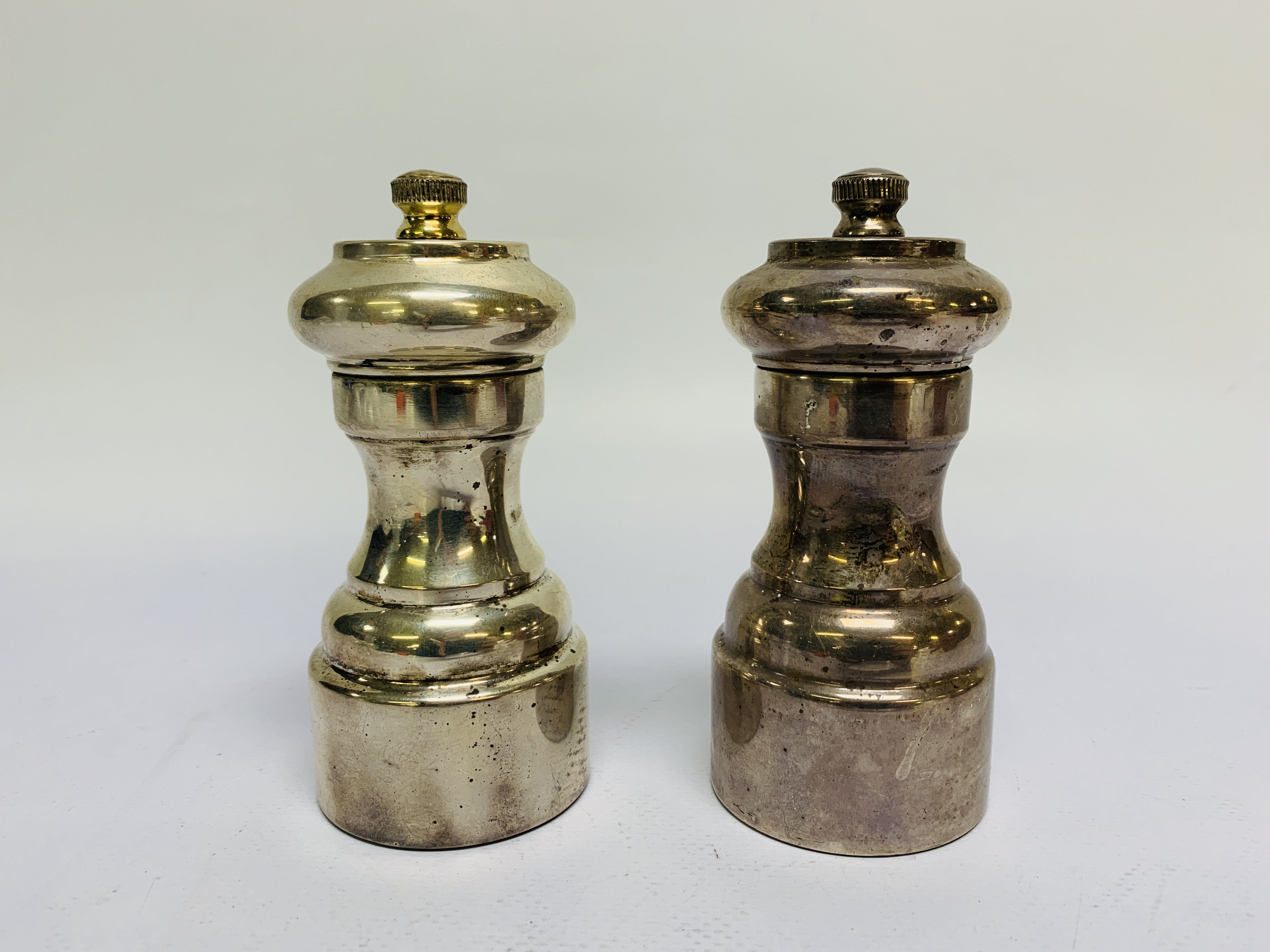 A SILVER PEPPER AND A SILVER SALT GRINDER OF SIMILAR CIRCULAR SHAPE,