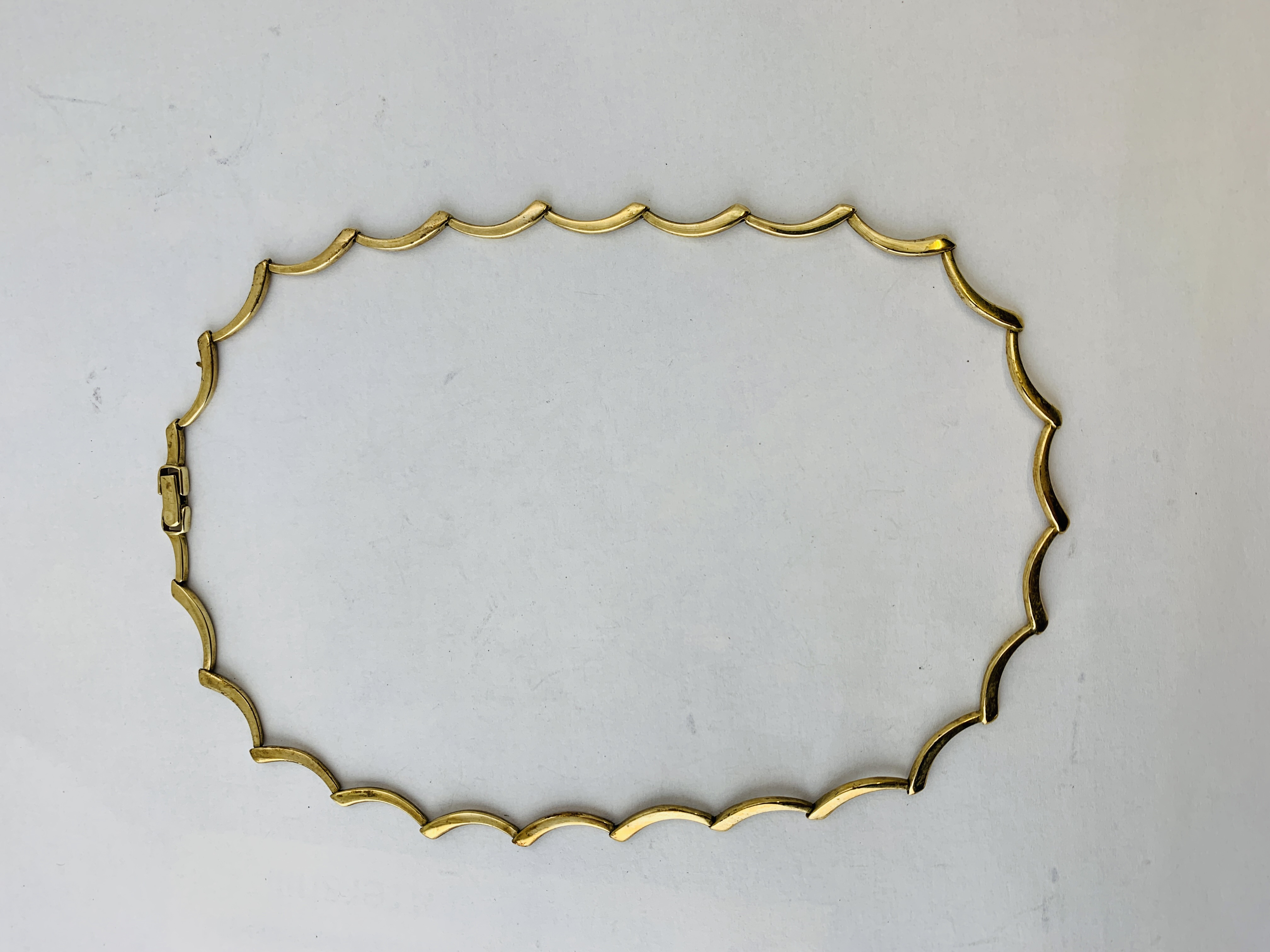 A 9CT GOLD CURVED BATTON LINK NECKLET