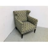 AN EDWARDIAN UPHOLSTERED WINGED EASY CHAIR