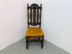 A HEAVILY CARVED OAK SIDE CHAIR WITH TAN LEATHER SEAT