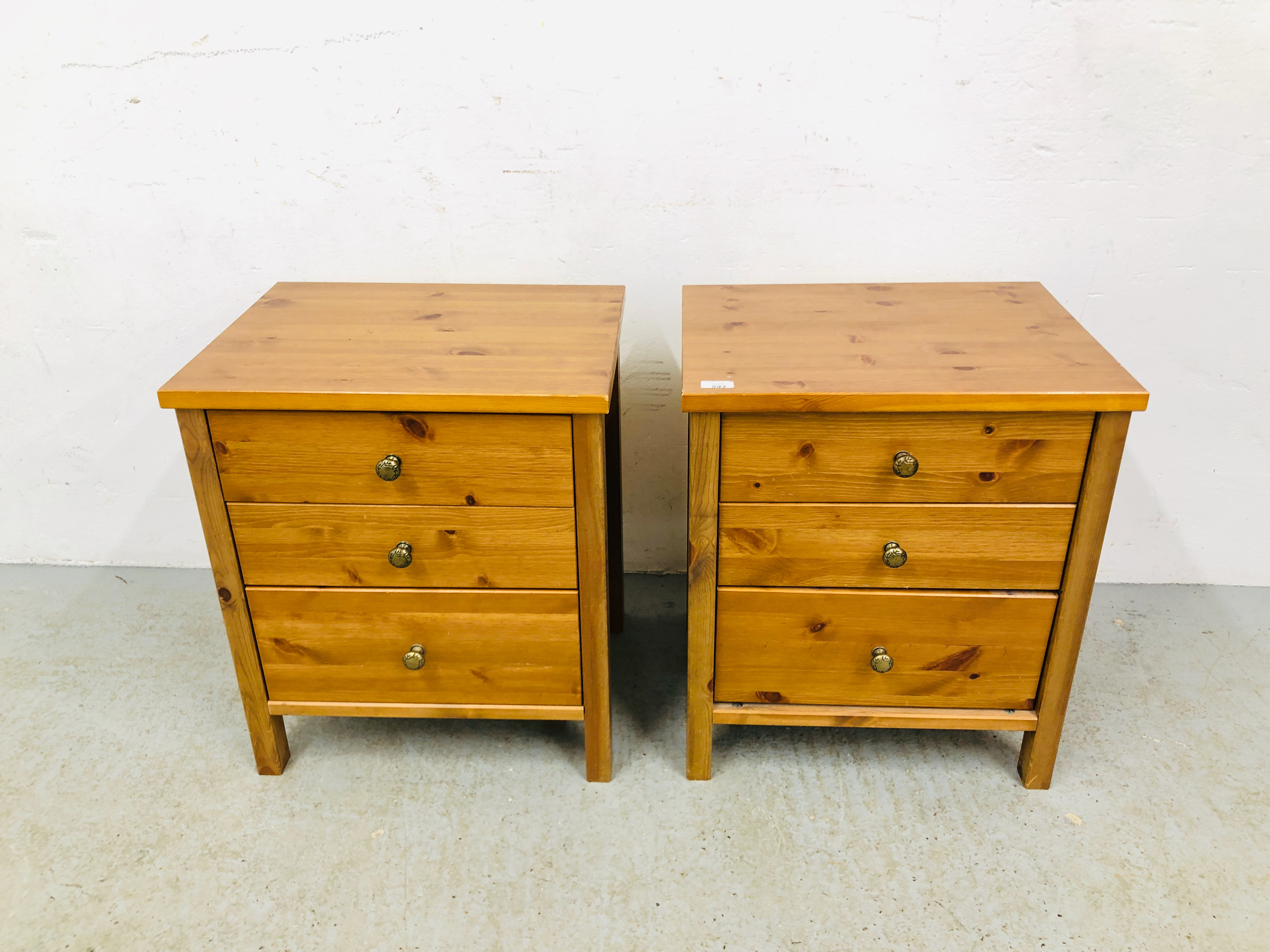 A PAIR OF HONEY PINE THREE DRAWER BEDSIDE CHESTS - W 53CM. D 41CM. H 61CM.