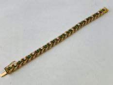 A BRAIDED DIAMOND AND EMERALD BRACELET MARKED 14K,