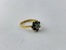 A DIAMOND AND GREEN STONE SET FLOWER HEAD RING (RUBBED MARKS)