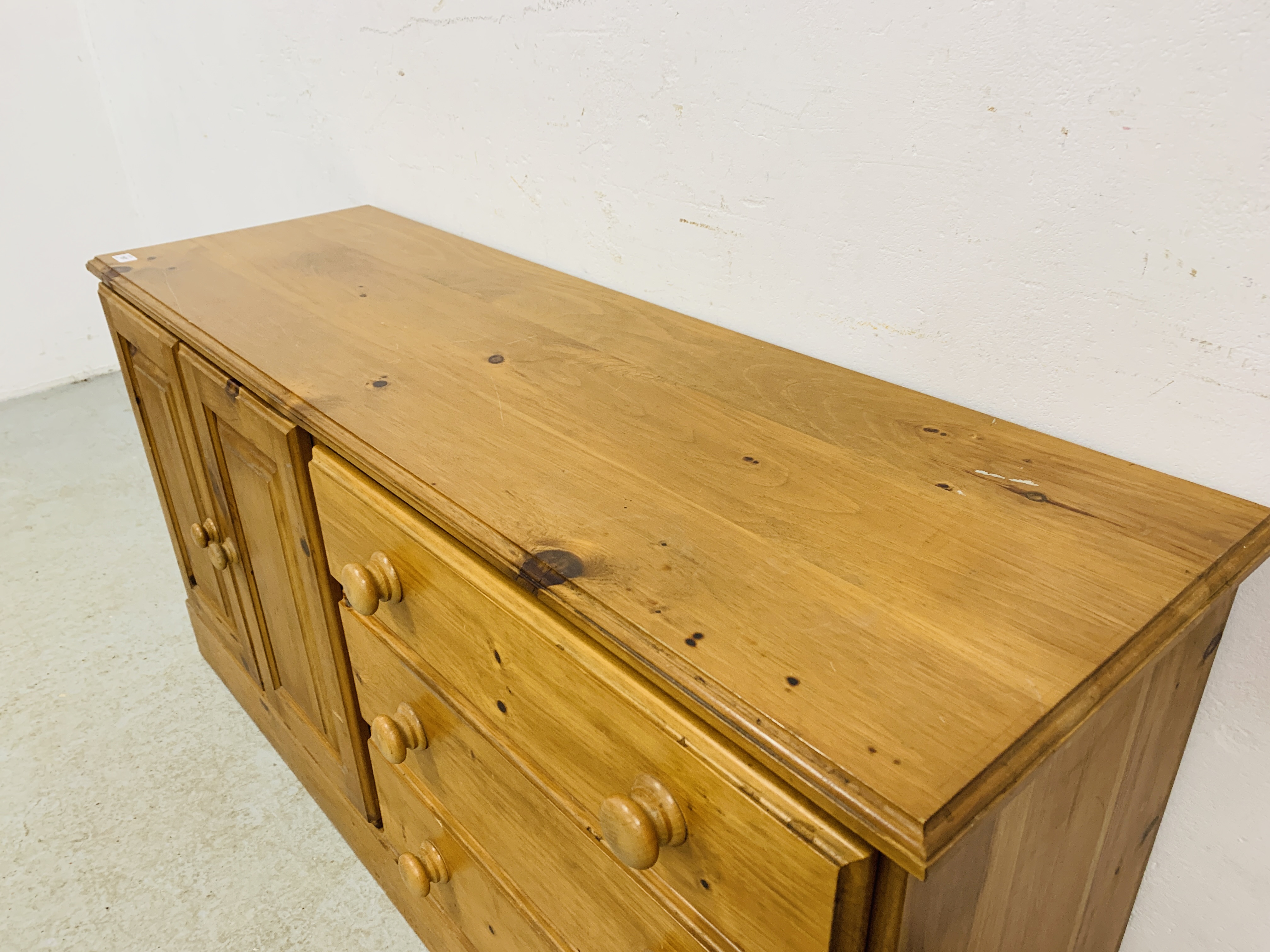 A SOLID HONEY PINE THREE DRAWER DRESSER BASE WITH CABINET TO ONE END - W 130CM. D 41CM. H 66CM. - Image 5 of 9