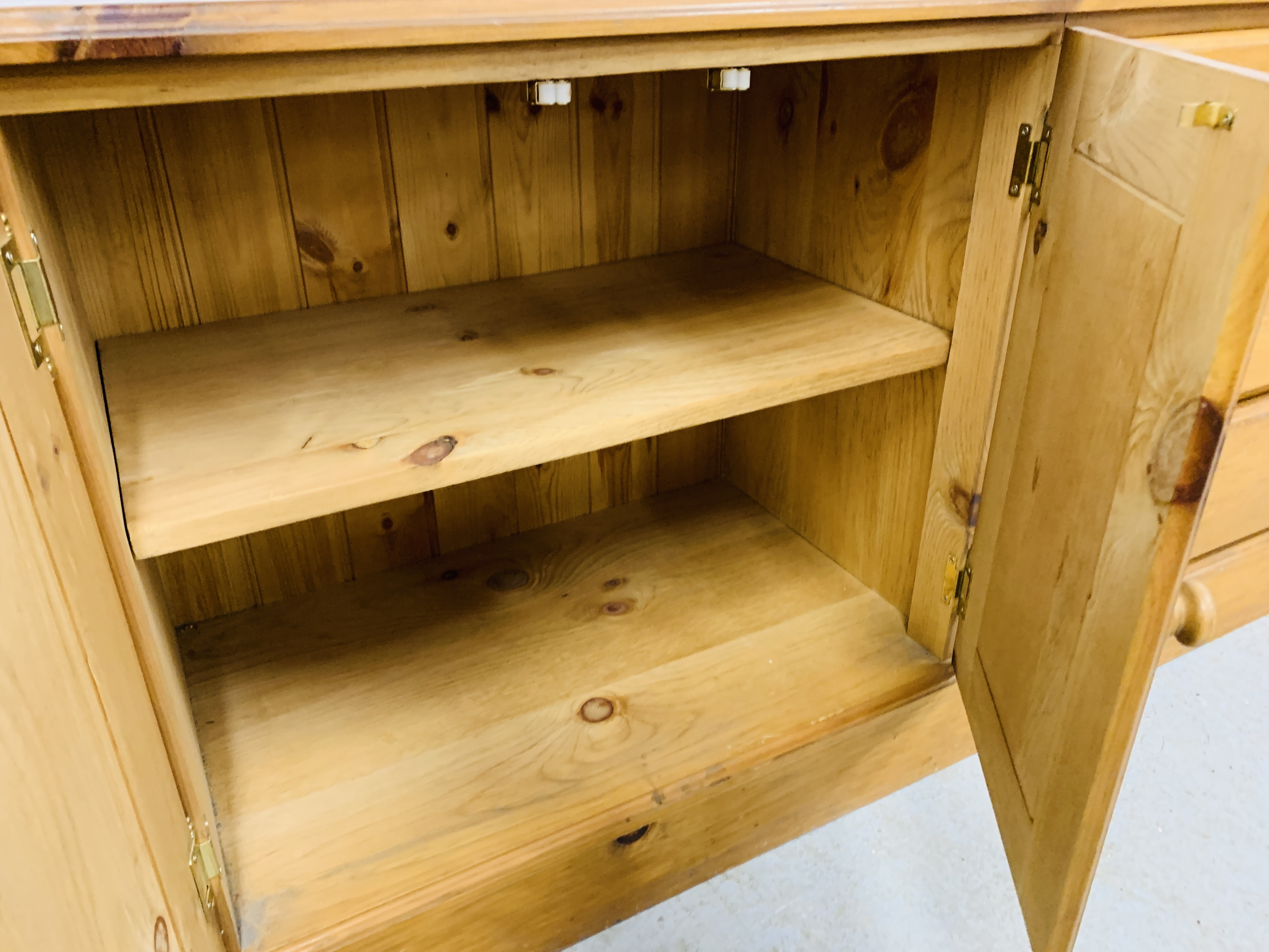 A SOLID HONEY PINE THREE DRAWER DRESSER BASE WITH CABINET TO ONE END - W 130CM. D 41CM. H 66CM. - Image 8 of 9