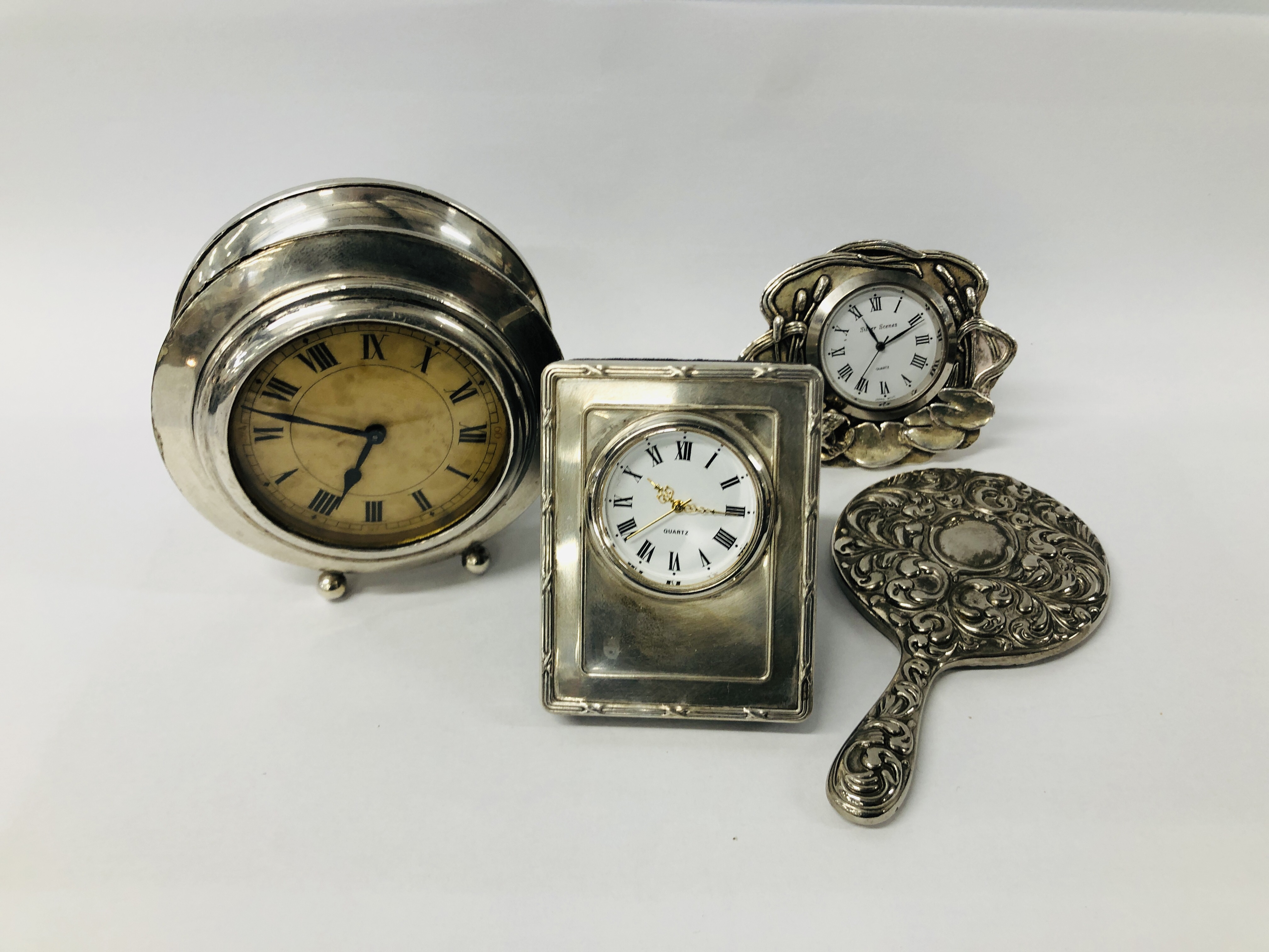 A SMALL SILVER CASED 30 HOUR BEDSIDE CLOCK ALONG WITH A SMALL QUARTZ CLOCK WITH SILVER MOUNT,