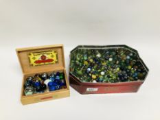 LARGE TIN OF ASSORTED VINTAGE GLASS MARBLES OF VARYING SIZES.