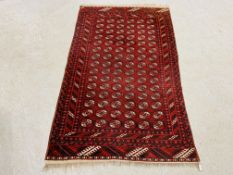 A MID 20TH CENTURY TURKOMAN RED PATTERNED RUG 122CM. X 194CM.