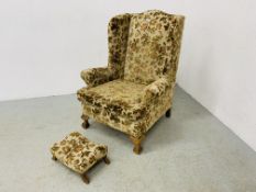 A WING BACK FIRE SIDE CHAIR UPHOLSTERED IN FLORAL BROCADE,