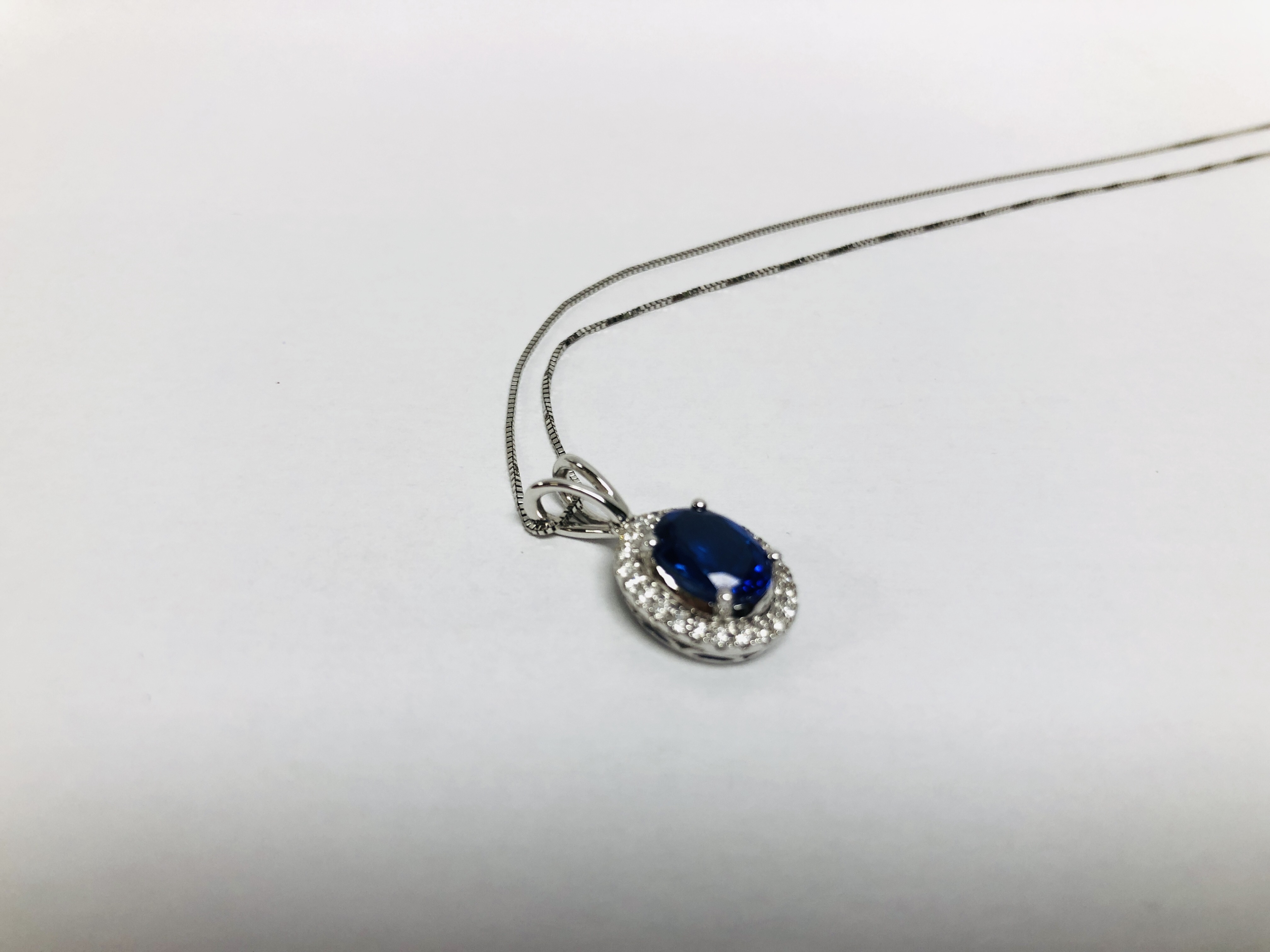 A PENDANT NECKLACE MARKED 750 THE PRINCIPLE BLUE STONE SURROUNDED BY DIAMONDS - Image 3 of 6