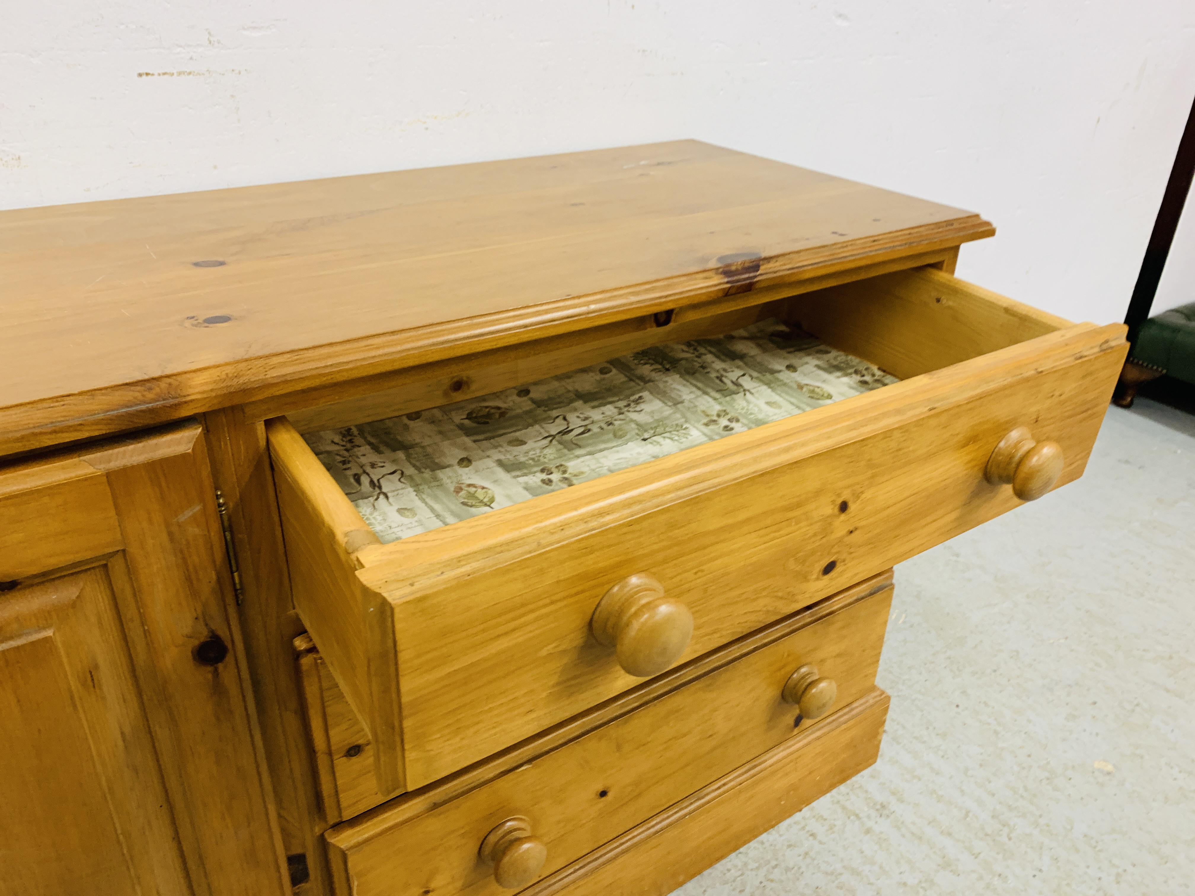 A SOLID HONEY PINE THREE DRAWER DRESSER BASE WITH CABINET TO ONE END - W 130CM. D 41CM. H 66CM. - Image 9 of 9