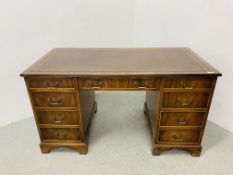 A REPRODUCTION MAHOGANY FINISH NINE DRAWER TWIN PEDESTAL DESK WITH INSET LEATHER TOP - W 138CM.
