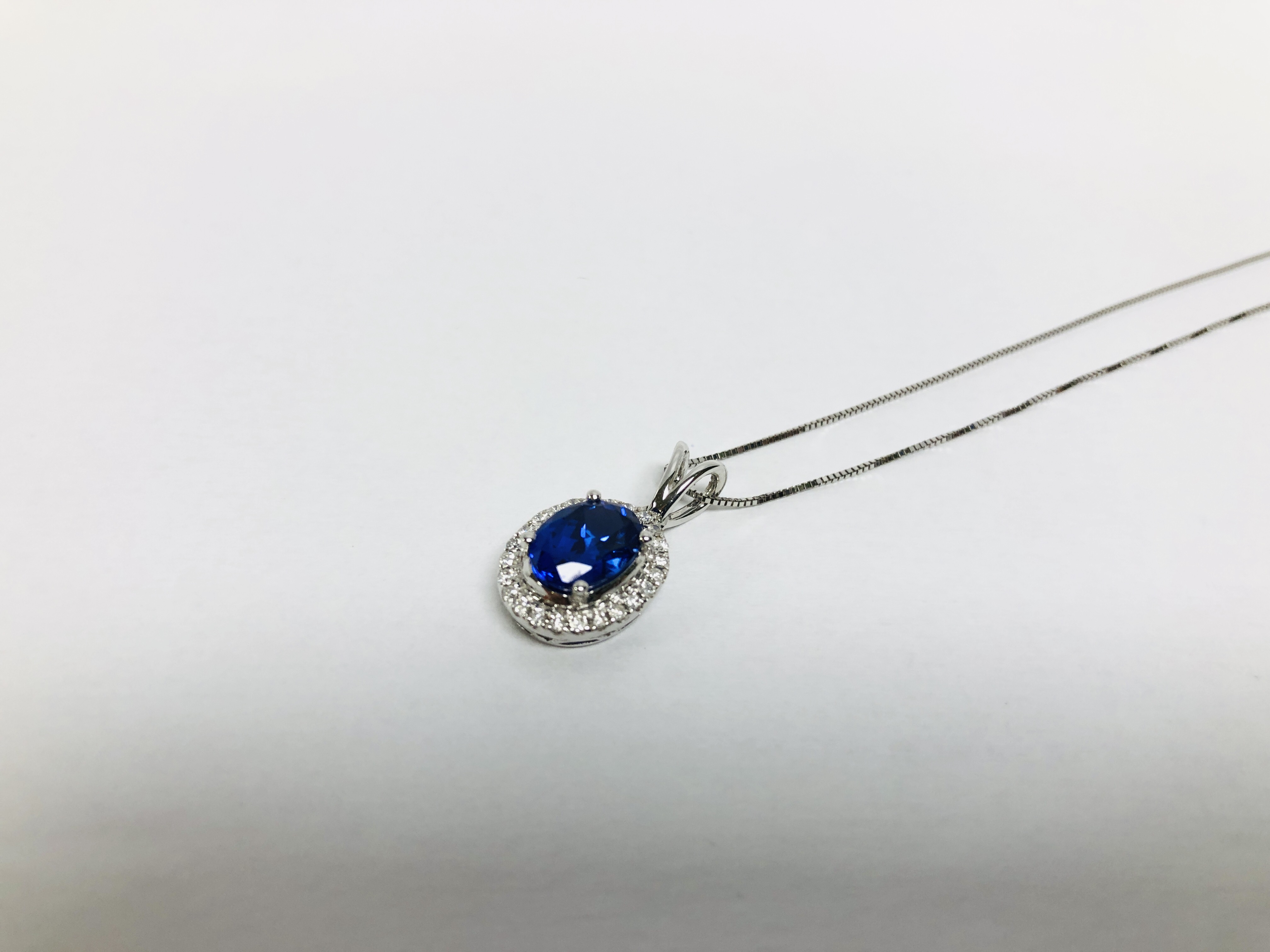 A PENDANT NECKLACE MARKED 750 THE PRINCIPLE BLUE STONE SURROUNDED BY DIAMONDS - Image 2 of 6