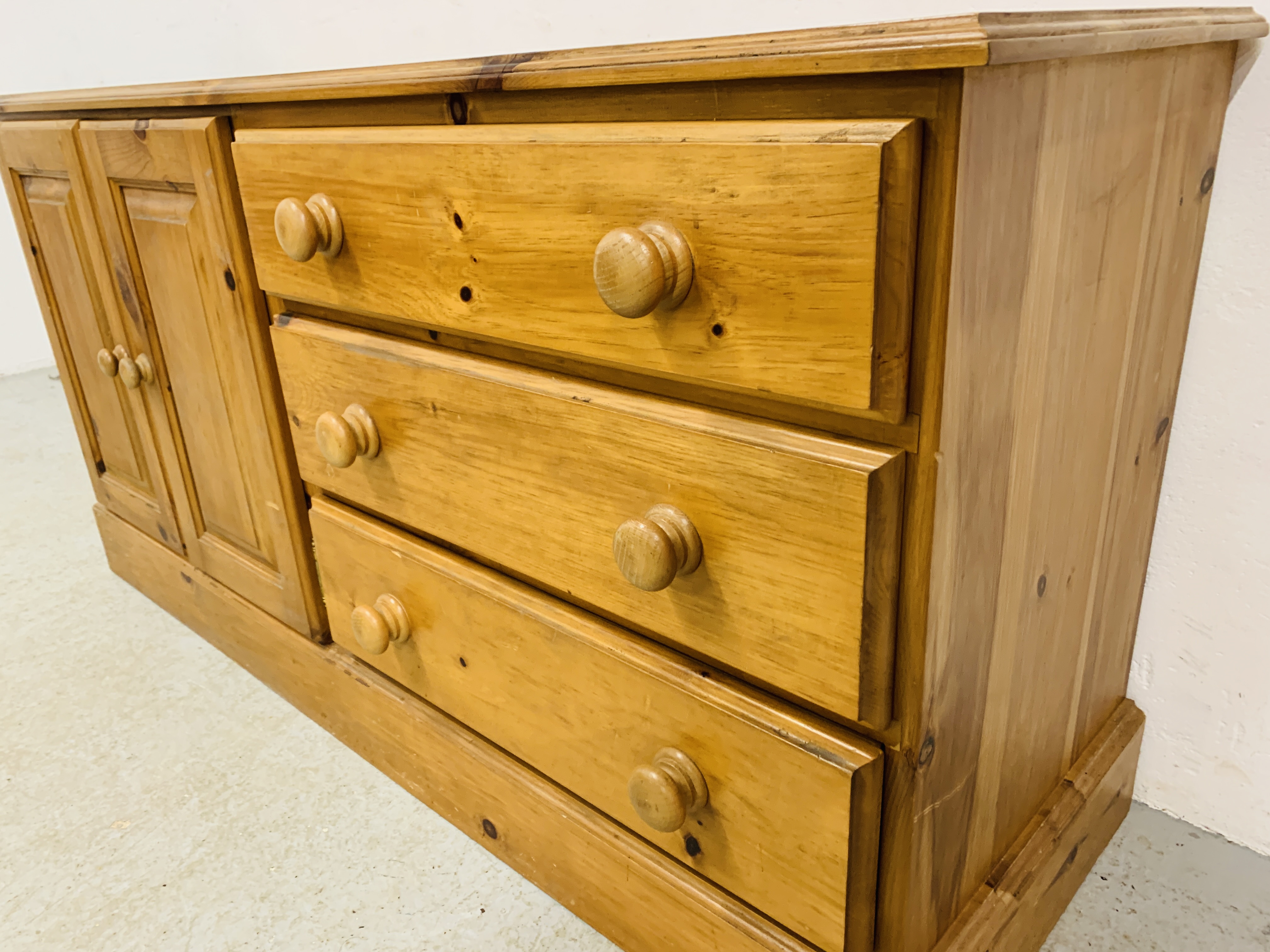 A SOLID HONEY PINE THREE DRAWER DRESSER BASE WITH CABINET TO ONE END - W 130CM. D 41CM. H 66CM. - Image 4 of 9