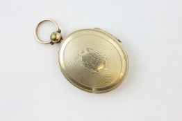 A YELLOW METAL OVAL LOCKET WITH ENGINE DECORATION, THE CARTOUCHE WITH MONOGRAM ON SUSPENSION LOOP,