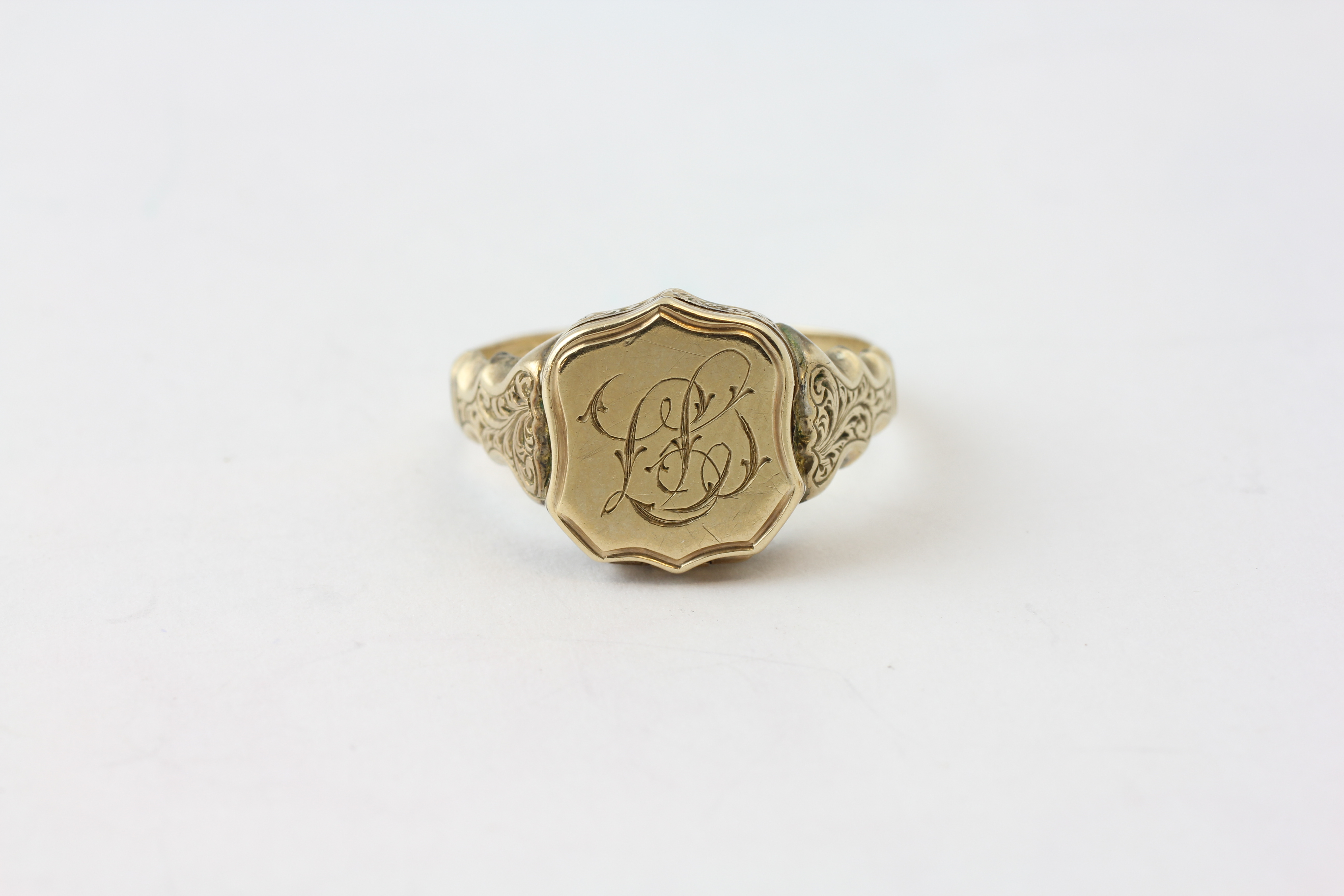 A 9CT GOLD SIGNET RING ENGRAVED WITH MONOGRAM, THE TOP HINGED REVEALING POCKET COMPARTMENT,