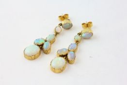 A PAIR OF SIX STONE OPAL DROP EARRINGS SET IN YELLOW METAL,