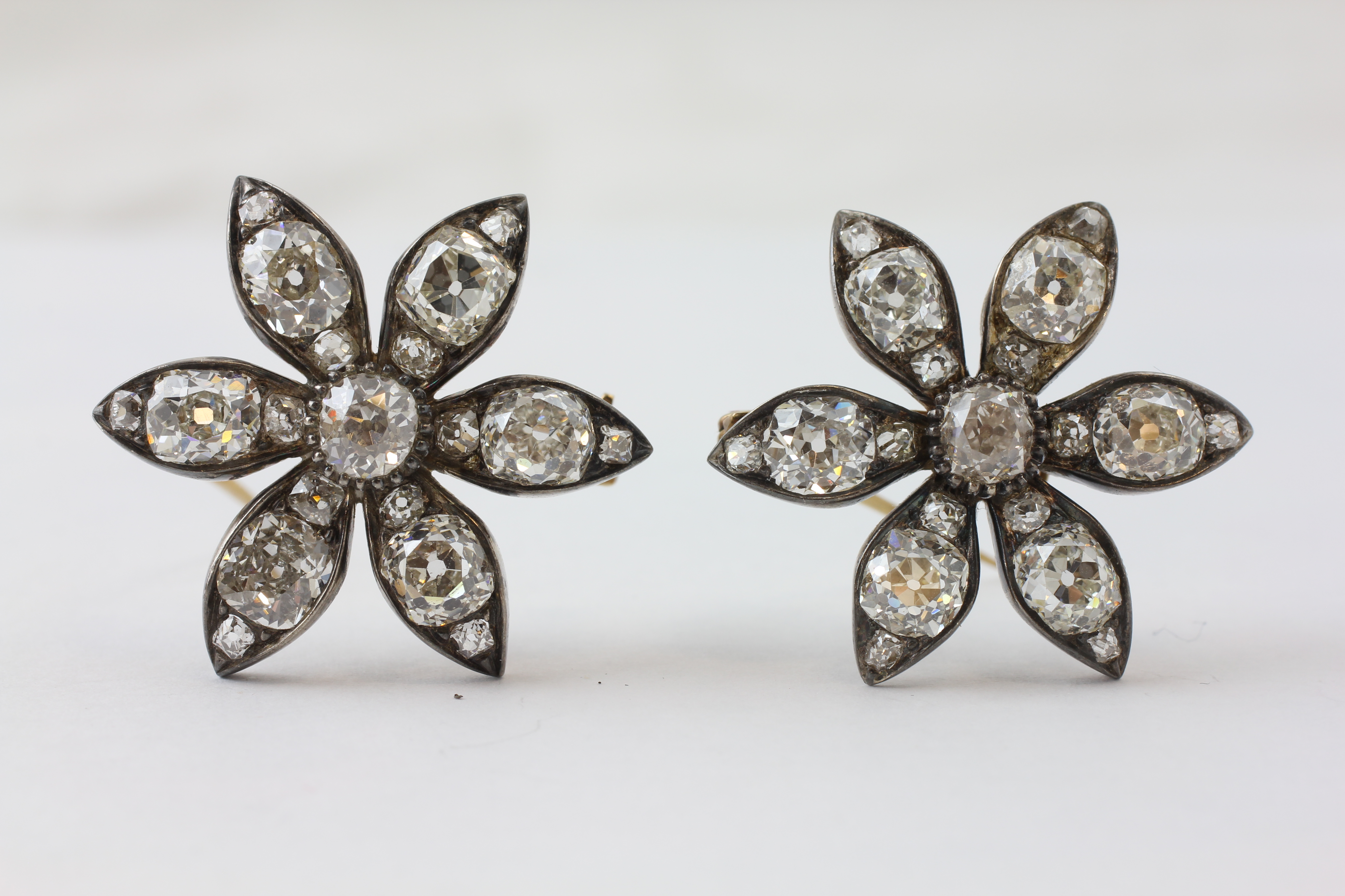 A PAIR OF DIAMOND FLOWERHEAD EARRINGS SET WITH OLD CUT STONES, THE ATTACHMENT ADJUSTABLE,