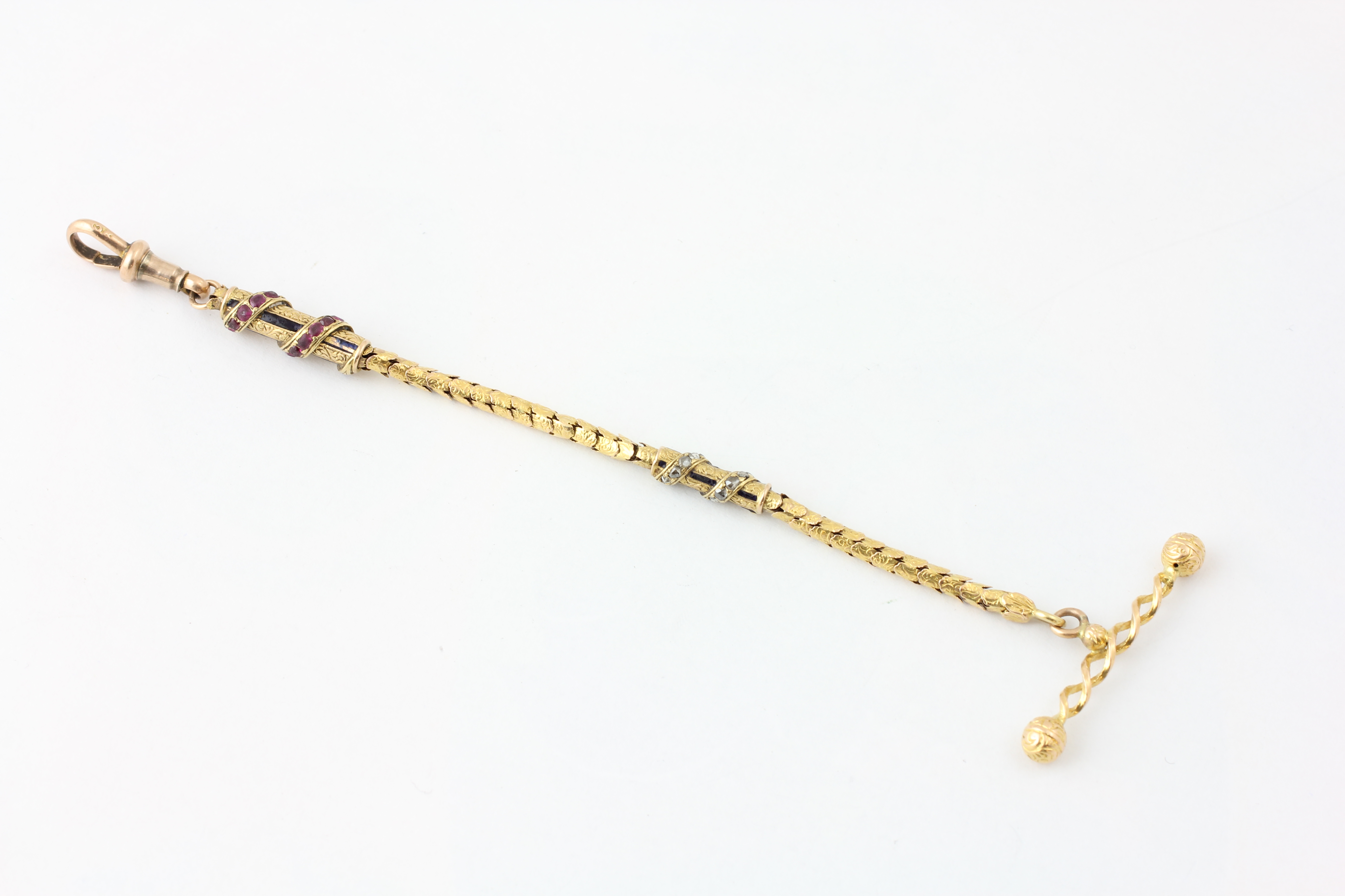 AN ARTICULATED WATCH CHAIN SET WITH RUBIES AND DIAMOND CHIPS, THE T BAR OF ROPE TWIST DESIGN,