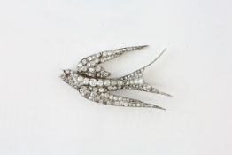 A DIAMOND SWALLOW BROOCH, THE EYE SET WITH A RUBY, LENGTH 58MM, THE LARGEST DIAMOND BEING 3MM,