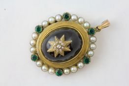 A VICTORIAN OVAL PENDANT, THE CENTRAL DARK RED CABOCHON MOUNTED WITH A STAR,
