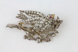 A BIRD BROOCH HAVING A RUBY EYE AND YELLOW METAL BEAK,