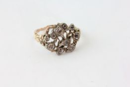 AN ANTIQUE RING SET WITH OLD CUT DIAMONDS IN A BIRD AND FLOWER DESIGN WITH FLOWERHEAD SHOULDERS,