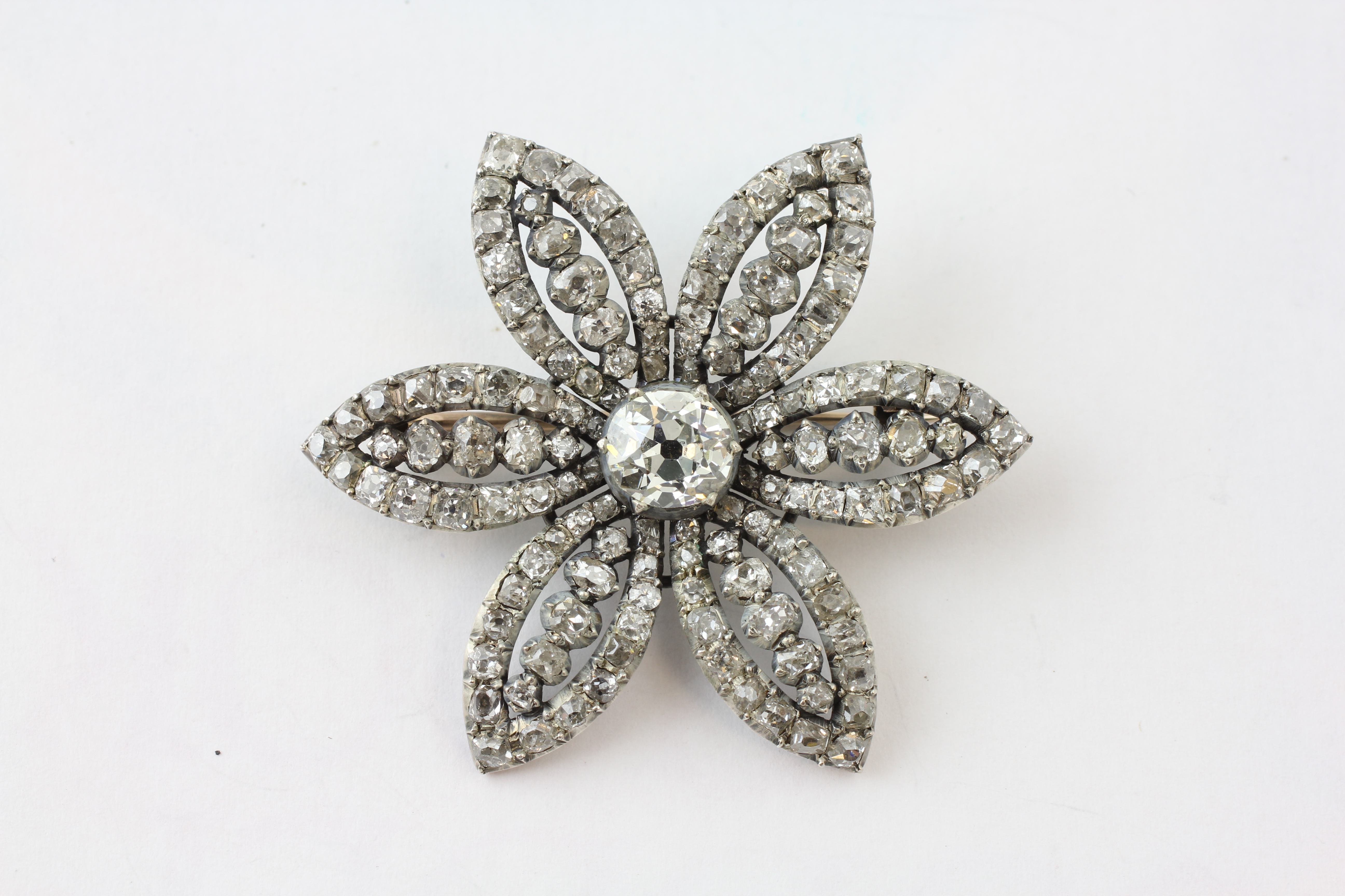 A SIX PETAL FLOWER HEAD DIAMOND BROOCH, SET WITH 133 DIAMONDS, THE CENTRAL STONE APPROXIMATELY 1CT,