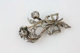 AN EDWARDIAN DIAMOND BROOCH OF FLOWERHEAD AND BOW DESIGN SET IN WHITE AND YELLOW PRECIOUS METAL,